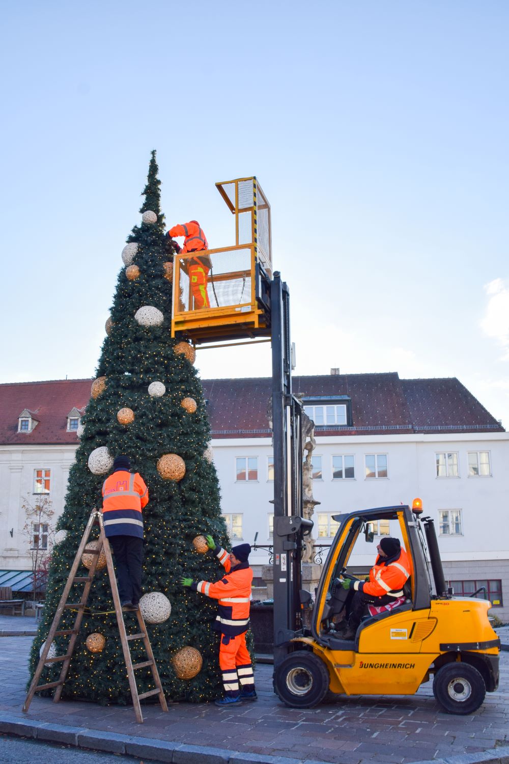 Christian Jerabek, Josef Brandner, Robert Juhitzer und David Kühhas im Arbeitskorb montieren den Weihnachtsbaum am Hauptplatz. Foto: Langstadlinger